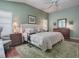 Bedroom featuring a large bed, wood floors, and a matching dresser at 320 Rhapsody Path, The Villages, FL 32162