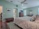 Spacious bedroom showcasing a large bed, wood floors, and ensuite bathroom at 320 Rhapsody Path, The Villages, FL 32162