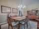 A dining room featuring a wooden table, decorative rug, and a sideboard displaying ornate glassware and artwork at 320 Rhapsody Path, The Villages, FL 32162