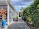 Walkway view with a gravel path, leading to a screened in porch and lush landscaping at 320 Rhapsody Path, The Villages, FL 32162