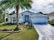 Charming single-story home with a well-manicured lawn, landscaped garden beds, and a spacious driveway at 320 Rhapsody Path, The Villages, FL 32162