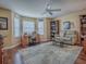 Inviting living room featuring hardwood floors, a cozy seating area, bookshelves, and a bright window at 320 Rhapsody Path, The Villages, FL 32162