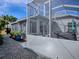 Exterior view of the back porch with a screened in jacuzzi and access to a gravel pathway at 320 Rhapsody Path, The Villages, FL 32162