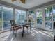 Sunroom with a table, tiled floors, and large windows overlooking the landscaped backyard at 320 Rhapsody Path, The Villages, FL 32162