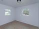 Simple bedroom with light walls, wood-look flooring, and two windows at 324 N York St, Bushnell, FL 33513