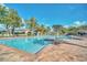 Resort-style pool with sun loungers, umbrellas, and palm trees against a bright blue sky at 3637 Hawkshead Dr, Clermont, FL 34711