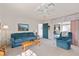 Cozy living room featuring a blue sofa and recliner, a ceiling fan, and a view of the outdoor patio at 3637 Hawkshead Dr, Clermont, FL 34711