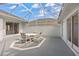 Enclosed patio with a white metal frame, gray flooring, and a charming dining set for outdoor entertaining at 3637 Hawkshead Dr, Clermont, FL 34711