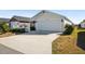 Front view of house with white garage door and picket fence at 3818 Zentko St, The Villages, FL 32163