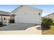 Front view of house with white garage door and picket fence at 3818 Zentko St, The Villages, FL 32163