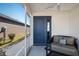 Screened porch entry with a blue door and small seating area at 3818 Zentko St, The Villages, FL 32163