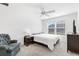 Bright bedroom features a ceiling fan, carpeted floor, a gray accent chair, and a large window at 3822 Miragalia Ln, The Villages, FL 32163