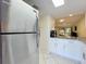 Stainless steel refrigerator in updated kitchen with white cabinets at 40 Moree Loop # 1, Winter Springs, FL 32708