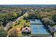 Aerial view showing tennis courts and a clubhouse in a tree-lined setting at 40 Moree Loop # 1, Winter Springs, FL 32708