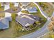 Lush aerial view of a luxurious home featuring a screened-in pool, manicured landscaping, and a well-maintained yard at 4515 Biggs Pl, The Villages, FL 32163