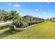 Landscaped backyard showcasing a screened enclosure, lush green grass, and a variety of verdant plant life at 4515 Biggs Pl, The Villages, FL 32163