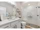 Bright bathroom with a shower that features decorative glass, white tiled walls, and bronze hardware at 4515 Biggs Pl, The Villages, FL 32163