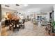 Open-concept dining area with wood floors, stylish furniture, and seamless flow to the living room and kitchen at 4515 Biggs Pl, The Villages, FL 32163