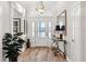Bright entryway with wood-look tile flooring, a decorative table, and views to the open living spaces at 4515 Biggs Pl, The Villages, FL 32163