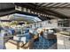 Covered lanai area features comfortable seating, an outdoor kitchen, and a view of the pool area at 4515 Biggs Pl, The Villages, FL 32163