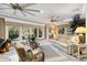 Bright living room with marble floors, wicker furniture, neutral paint, and lots of windows at 4515 Biggs Pl, The Villages, FL 32163