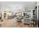 Open-concept living room featuring wood-look tile flooring, modern furniture, and seamless flow to the kitchen at 4515 Biggs Pl, The Villages, FL 32163