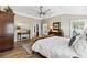 Bright main bedroom featuring wood-look tile flooring, shutters, and a view of the ensuite bathroom at 4515 Biggs Pl, The Villages, FL 32163