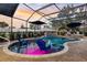 Stunning screened-in pool area with stylish lounge chairs, a bar area, and tranquil garden views at sunset at 4515 Biggs Pl, The Villages, FL 32163