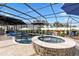 In-ground pool and spa featuring a sun shelf and screened enclosure for outdoor entertaining at 4515 Biggs Pl, The Villages, FL 32163