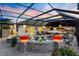 Outdoor pool area at twilight featuring a screened-in enclosure, spa, and outdoor seating at 4515 Biggs Pl, The Villages, FL 32163