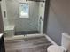 Updated bathroom featuring a walk-in shower with marble tile and gray walls at 4520 N Hiawassee Rd, Orlando, FL 32818