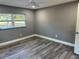 Bedroom with grey walls, wood-look flooring, and a window offering natural light at 4520 N Hiawassee Rd, Orlando, FL 32818