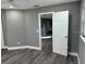 Bedroom with grey walls, wood-look flooring, ceiling fan, and access to another room at 4520 N Hiawassee Rd, Orlando, FL 32818