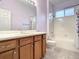 Bathroom with wood vanity, tiled shower and bathtub at 4985 Rainbow Trout Rd, Tavares, FL 32778