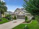 Two-story house with a screened porch, two-car garage, and landscaped yard at 4985 Rainbow Trout Rd, Tavares, FL 32778