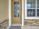 Front door with a decorative glass insert and stone accents at 4985 Rainbow Trout Rd, Tavares, FL 32778