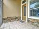 Front porch with tiled floor, stone accents, and a door with glass at 4985 Rainbow Trout Rd, Tavares, FL 32778