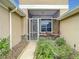 Screened porch entrance with decorative gate and stone accents at 4985 Rainbow Trout Rd, Tavares, FL 32778