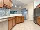 Modern kitchen with wood cabinets, tile backsplash, and granite countertops at 4985 Rainbow Trout Rd, Tavares, FL 32778