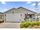 Tan one-story house with white picket fence and American flag at 6206 Dingman Way, The Villages, FL 32163