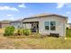 Tan house exterior with screened patio and landscaping at 6206 Dingman Way, The Villages, FL 32163