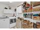 Well-organized laundry room with washer, dryer, and ample storage shelving at 6206 Dingman Way, The Villages, FL 32163