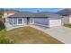 One-story gray house with white garage door and surrounding landscape at 6739 Lorain Street, Orlando, FL 32810