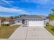 Gray house with white garage doors, and a driveway at 6739 Lorain Street, Orlando, FL 32810