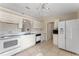 White kitchen with stainless steel appliances and tile flooring at 6739 Lorain Street, Orlando, FL 32810