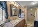 Bathroom with granite countertop, walk-in shower, and updated fixtures at 705 Devon Dr, Lady Lake, FL 32159