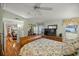 Bright bedroom with wood flooring, ceiling fan, and views of kitchen at 705 Devon Dr, Lady Lake, FL 32159