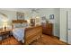 Bedroom with wood sleigh bed, hardwood floors, and dresser at 705 Devon Dr, Lady Lake, FL 32159