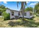 Side view of a single story home with AC unit and palm tree at 705 Devon Dr, Lady Lake, FL 32159