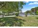 White single-story home with large yard and mature trees at 705 Devon Dr, Lady Lake, FL 32159